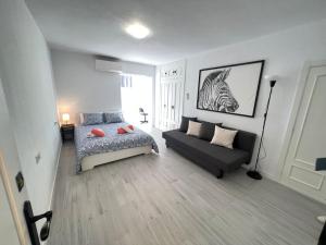 a bedroom with a bed and a couch in it at Playamar Feliz in Torremolinos +41 photos