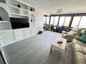a living room with a couch and a tv at Playamar Feliz in Torremolinos