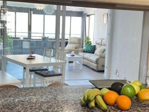 a kitchen and living room with a table with fruit on the counter at Playamar Feliz in Torremolinos