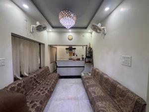 una sala de espera con sofás y una lámpara de araña en Lucky Guest House Bodhgaya, en Bodh Gaya