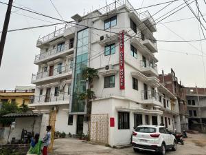 un edificio con un coche blanco aparcado delante de él en Lucky Guest House Bodhgaya, en Bodh Gaya