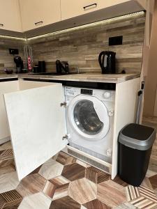 eine Waschmaschine in einer Küche mit einer Theke in der Unterkunft Апартамент Божур in Warna