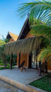 a building with a bench and a grass roof at LE VAHINÉ Eco-RESORT in Toliara