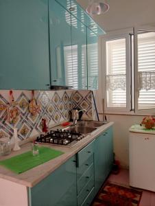 a kitchen with a sink and a stove top oven at Terrazza Faraglioni in Acitrezza
