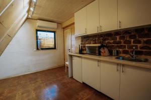 a kitchen with white cabinets and a brick wall at BlackWood A frame in Nurrnus