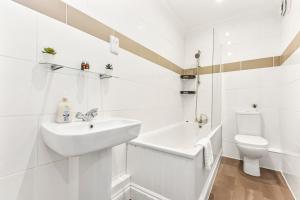 ein weißes Bad mit einem Waschbecken und einem WC in der Unterkunft Cosy 2 bed flat near London Eye in London