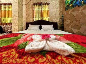 una camera da letto con un letto e un asciugamano sopra di Hotel Shogondha Residential, a Dhaka
