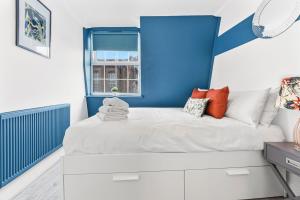 ein Schlafzimmer mit einem weißen Bett und einer blauen Wand in der Unterkunft Cosy 2 bed flat near London Eye in London