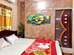 1 dormitorio con 1 cama con una pintura en la pared en Hotel Shogondha Residential,, en Dhaka