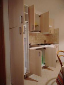 eine Küche mit Holzschränken und einem weißen Kühlschrank in der Unterkunft Ferienwohnung für 6 Personen ca 75 m in Pellizzano, Trentino Val di Sole in Trient