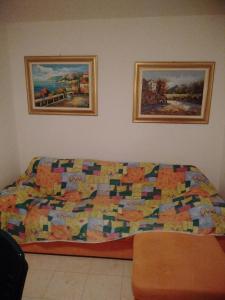 ein Bett in einem Schlafzimmer mit zwei Bildern an der Wand in der Unterkunft Ferienwohnung für 6 Personen ca 75 m in Pellizzano, Trentino Val di Sole in Trient