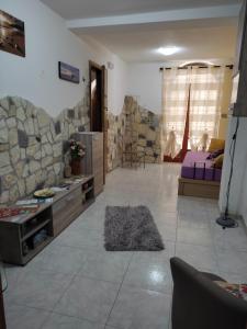 una gran sala de estar con una pared de piedra. en Dolce Risveglio en Cefalú