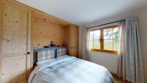- une chambre avec un lit dans une pièce dotée d'une fenêtre dans l'établissement Aroevens, à Pontresina
