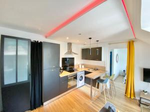 een keuken en een woonkamer met een tafel en stoelen bij LE CACTUS - Beau T2 - 10 min du centre à pied et parking facile in Quimper