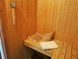 a wooden bench in a sauna with a clock at Gemütliches Ferienhaus Lea für 5 Personen mit Sauna und Kaminofen von Privat im Ferienpark Extertal in Extertal