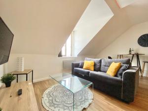 a living room with a couch and a glass table at LE CACTUS - Beau T2 - 10 min du centre à pied et parking facile in Quimper