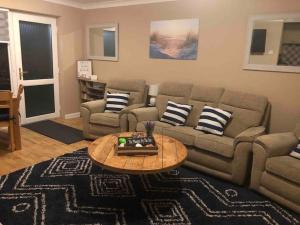 a living room with a couch and a table at The Phoenix by the Sea- 2 bedroom flat in hunny in Hunstanton