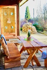 uma mesa de piquenique em madeira e uma cadeira num pátio em Ruhig gelegener Ferienbungalow mit Terrasse und Garten am Waldrand em Bad Elster