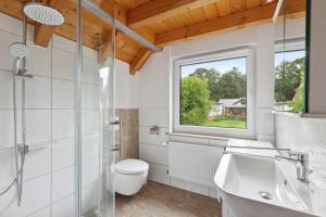 a bathroom with a sink toilet and a window at Ferienhaus in Krimderode mit Grill, Whirlpool und Terrasse in Nordhausen