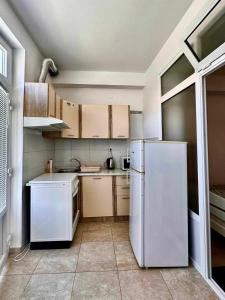 cocina con nevera blanca y armarios en Apartment Asi, en Dubrovnik