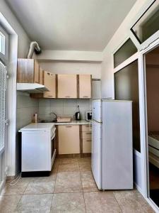 a kitchen with a white refrigerator and cabinets at Apartment Asi in Dubrovnik