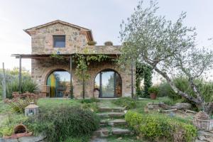 una casa de piedra con un arco en un jardín en Il Poggio Dell'Eremita, en Rigomagno