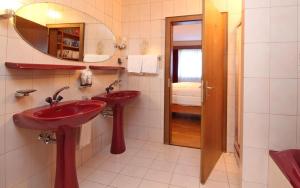 a bathroom with two red sinks and a mirror at Chesa Alice in St. Moritz