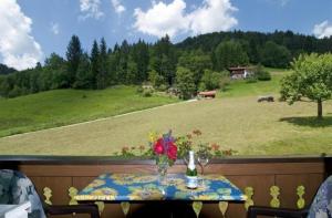 uma mesa numa varanda com vista para um campo em Ferienwohnung für 4 Personen ca 55 qm in Reit im Winkl, Bayern Oberbayern em Reit im Winkl