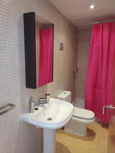 La salle de bains est pourvue d'un lavabo et d'un rideau de douche rose. dans l'établissement Haus DORNA, à L'Escala