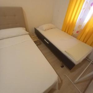 two beds in a small room with a window at Aurora Room with Private Bathroom in Alicante