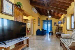 sala de estar con TV de pantalla plana grande en Il Poggio Dell'Eremita, en Rigomagno