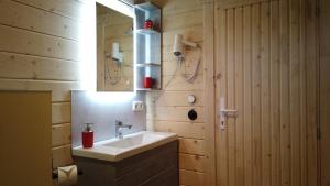 a bathroom with a sink and a mirror at Wellnorama 2 - WellnessFerienhaus mit Pool, Sauna und eigenem Whirlpool mitten in Deutschland in Wasungen +16 photos