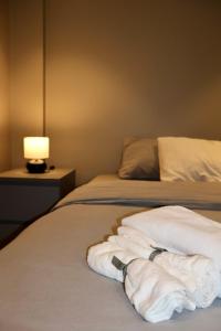 - un lit avec 2 serviettes blanches et une lampe dans l'établissement Solsiden Modern stay: King Beds, Private Entry, à Trondheim
