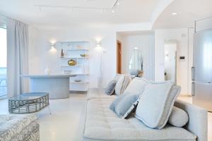 a white living room with a couch and a table at Isrotel 2BR Just Like The Sea by HolyGuest in Tel Aviv