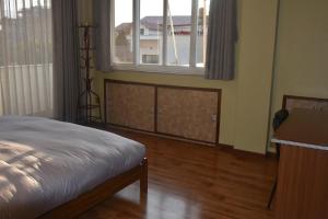 Schlafzimmer mit einem Bett, einem Schreibtisch und einem Fenster in der Unterkunft Shine Homestay Famille Francophone - Shine Home and Apartment in Kathmandu