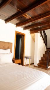 a bedroom with a white bed and a staircase at LE VAHINÉ Eco-RESORT in Toliara