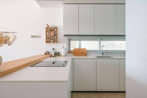 フエンヒロラにあるMed Two luxury apartment with sea viewの白いキッチン(白いキャビネット、シンク付)