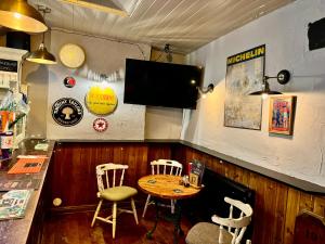 a bar with a table and chairs and a television at The Black Swan Hotel in Leyburn