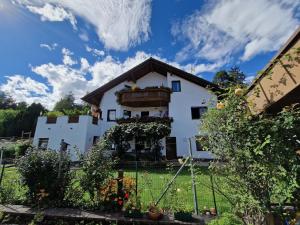 una casa bianca con una recinzione di fronte di Große Ferienwohnung in Imst mit Balkon und Panoramablick auf die Ötztaler und Pitztaler Alpen a Imst