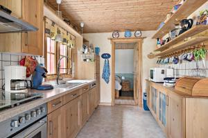 een keuken met houten kasten en een wastafel bij Idyllisch gelegenes ebenerdiges Ferienhaus mit Terrasse und Wintergarten mit traumhaften Blick in die Weite der Umgebung in Svenljunga