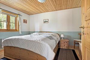 een slaapkamer met een bed en een houten plafond bij Idyllisch gelegenes ebenerdiges Ferienhaus mit Terrasse und Wintergarten mit traumhaften Blick in die Weite der Umgebung in Svenljunga