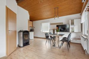 a kitchen and dining room with a table and a stove at Ferienhaus mit naturnahen Badeteich in Nordhausen