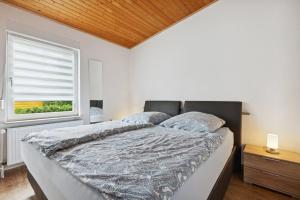 a bedroom with a large bed with a window at Ferienhaus mit naturnahen Badeteich in Nordhausen