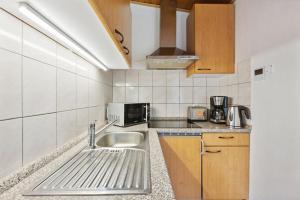 a small kitchen with a sink and a microwave at Ferienhaus mit naturnahen Badeteich in Nordhausen