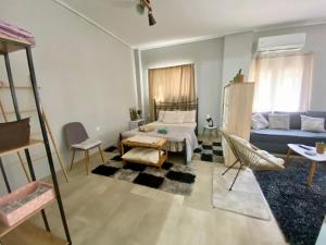a living room with a bed and a couch at Xrysa's Central City Apartment in Missolonghi +22 photos