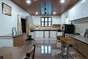 a large kitchen with a table and some chairs at Reunion Ocean Bliss in Udupi