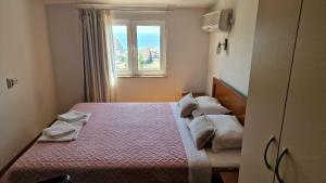 a bedroom with two beds and a window at Vila Lena in Petrovac na Moru