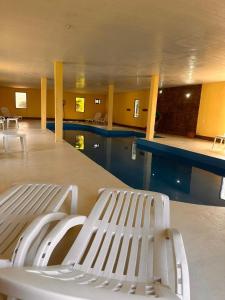 a swimming pool with a white bench in a building at Cabañas Altos de Artalaz in Colón