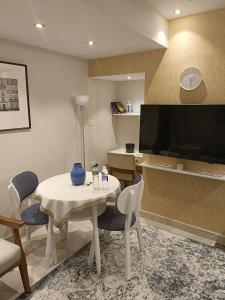 ein Wohnzimmer mit einem Tisch mit Stühlen und einem TV in der Unterkunft ستوديو فندقى فاخر بالزمالك in Kairo