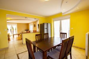 cocina y comedor con mesa de madera y sillas en Villa Aruba en Grzybowo